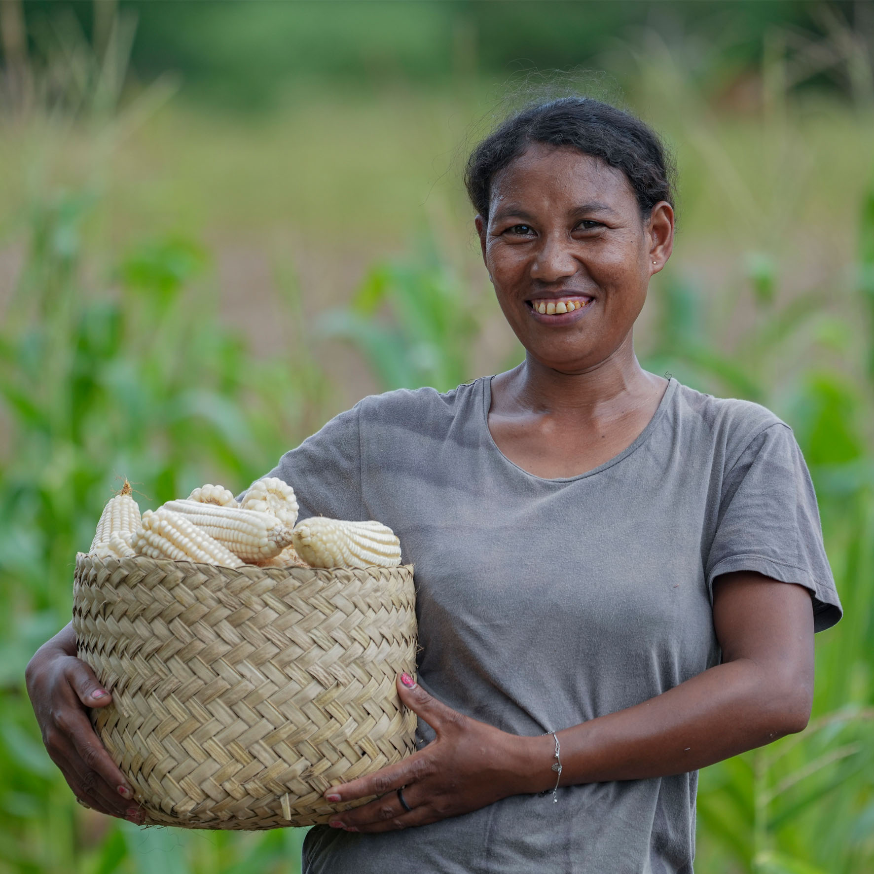 a woman mung bean farmer wearing traditional cloth standing in front of her house